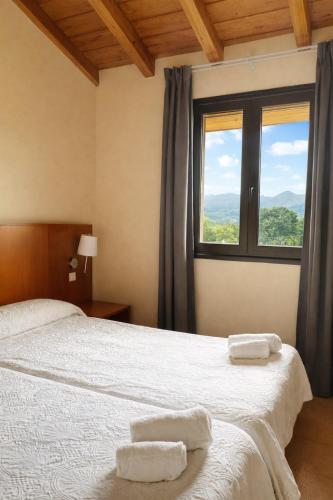 a bedroom with two beds and a window at Hotel Ibaigune in Murueta