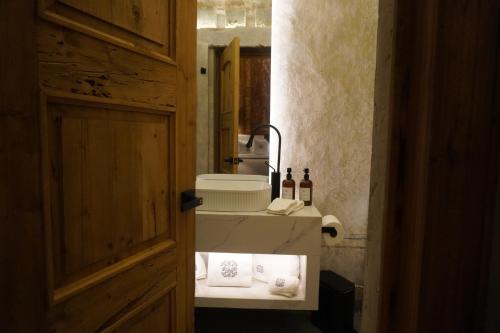 a bathroom with a sink and a mirror and a door at Por los Siglos de los Siglos Hotel in Huamantla