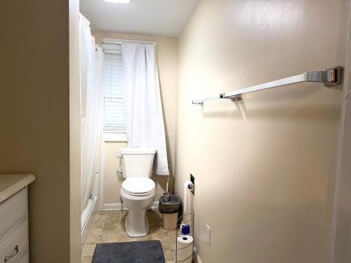 a small bathroom with a toilet and a window at Brick House Retreat in Hamlet