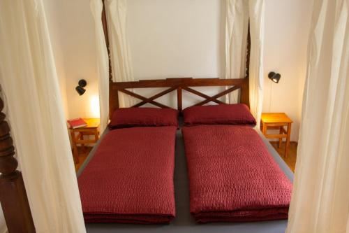 three red pillows on a bed in a room at Herbergskirche Spangenberg - Stimmungsvolle Schlafräume, jedoch ist NUR das Badzimmer beheizt in Spangenberg