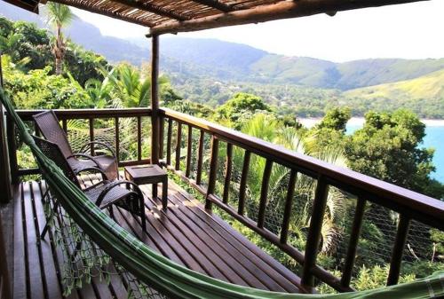 a hammock on a balcony with a view of the mountains at Ilha de Toque Toque Eco Hotel in São Sebastião