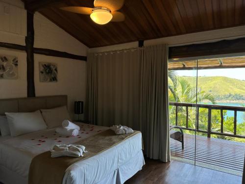 a bedroom with a bed and a large window at Ilha de Toque Toque Eco Hotel in São Sebastião