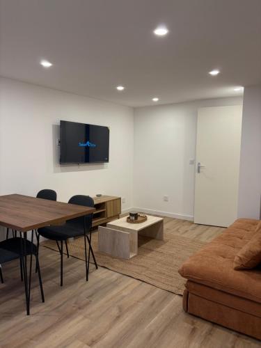 a living room with a table and a couch at Charmant appartement moderne D in La Roche-sur-Yon