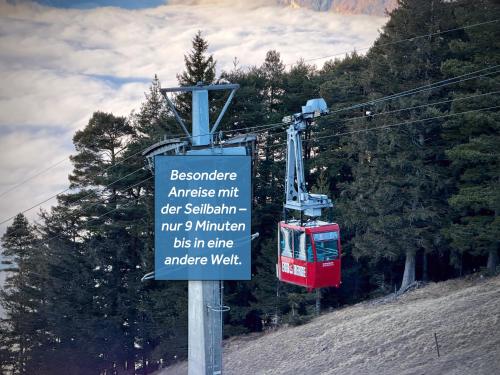 a sign for a ski lift with a red tram at Berggasthaus Eggberge - Boutique Mountain Hotel - Access via Cablecar in Altdorf