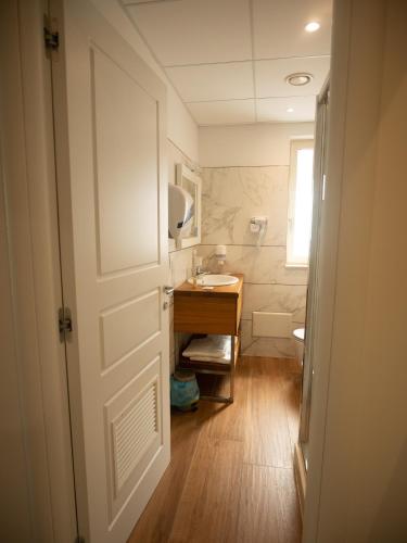 a bathroom with a sink and a toilet and a door at ROOMS alCentro in Catania