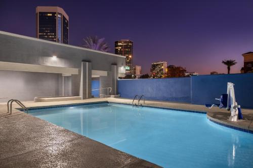 a swimming pool with a city skyline in the background at Holiday Inn Express & Suites Phoenix - Midtown, an IHG Hotel in Phoenix