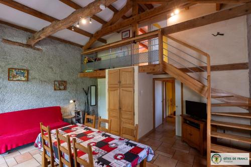 a living room with a red couch and a loft at Le Gîte de Saint Izaire in Saint-Izaire