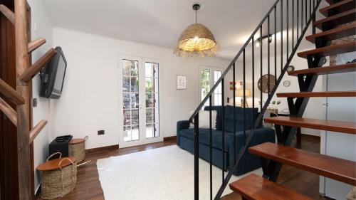 a living room with a staircase and a tv at Stonewood Valley by LovelyStay in Curral das Freiras