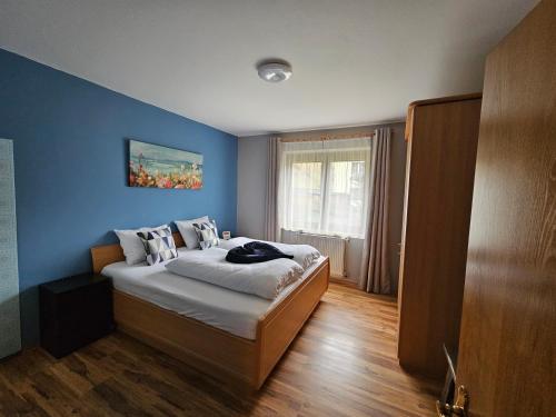 a bedroom with a bed with a blue wall at Mirnockblick Apartments in Radenthein