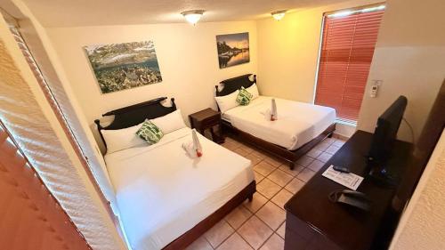a hotel room with two beds and a television at Mayan Princess Beach & Dive Resort in West Bay
