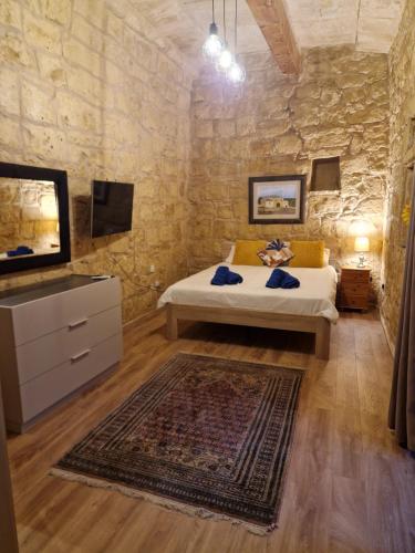a bedroom with a bed and a flat screen tv at Cozy 1 Bedroom House in Iz-Zejtun in Żejtun