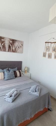 a bedroom with two beds and a painting on the wall at Apartament La Mata -Maya Bungalow in Torrevieja