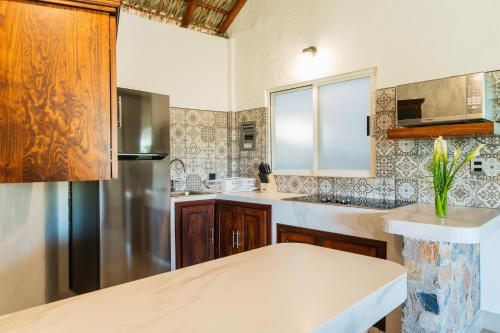 a kitchen with a refrigerator and a sink at Villas & Resort Luz de Luna in Santa Cruz Huatulco