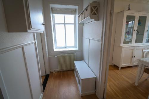 a kitchen with a white refrigerator and a window at Spacious 3-Bedroom Apartment with Comfy Beds in Central Vágur, Island of Suðuroy in Vágur