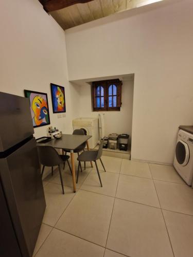 a kitchen and dining room with a table and a microwave at Cozy 1 Bedroom House in Iz-Zejtun in Żejtun