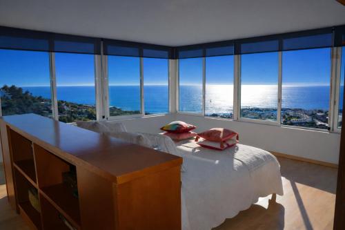 a bedroom with a bed with a view of the ocean at Villa Sitges Altavista Amazing View South oriented Calm Area AC Beach 2 minutes Drive and 18 minutes Walk in Sitges