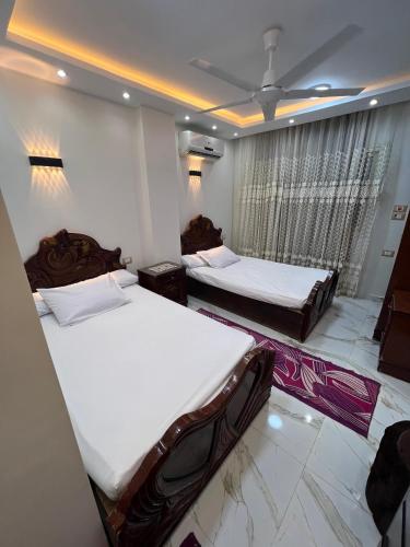 a bedroom with two beds and a window at Flat in Nag` el-Ramla