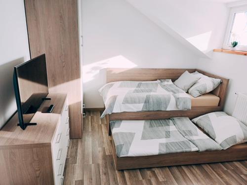 a bedroom with two beds and a desk at Apartmán Altis in Tatranska Strba