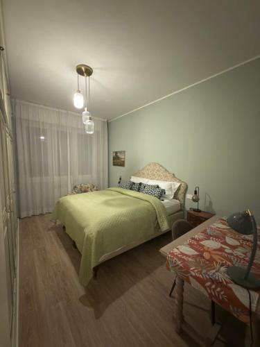 a bedroom with a green bed and a table at Brugnoli 13 Guest House in Bologna