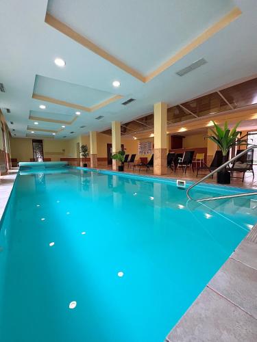 a large swimming pool in a hotel lobby at Dorina Wellness Apartman in Siófok