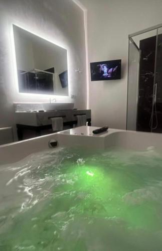 a bath tub filled with green water in a bathroom at Palazzo Papa Gregorio XVI in Tivoli