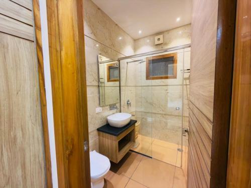 a bathroom with a toilet and a sink and a shower at Hotel Silver Bricks in Amritsar