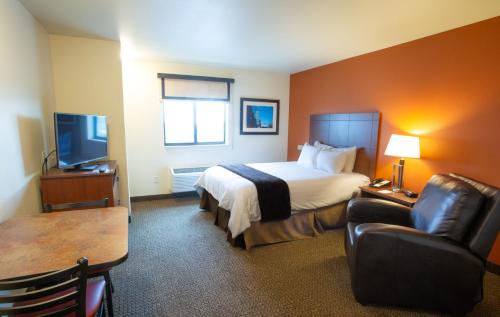 a hotel room with a bed and a chair and a table at My Place Hotel-Davenport/Quad Cities, IA in Davenport