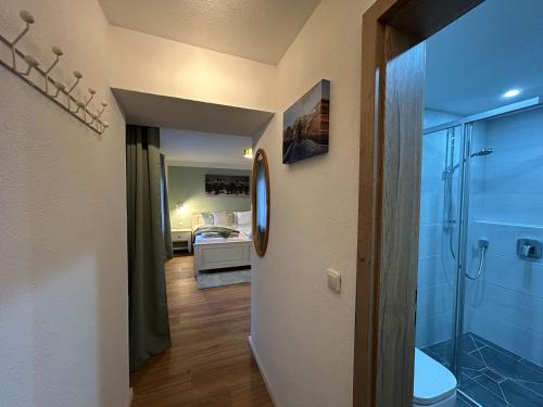 a bathroom with a shower and a toilet and a bedroom at Gästehaus Math in Oberstdorf