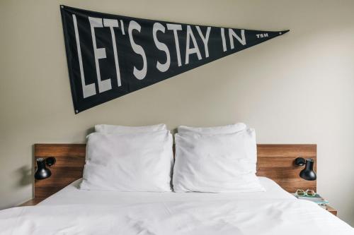 a black and white sign hanging above a bed at The Social Hub The Hague in The Hague