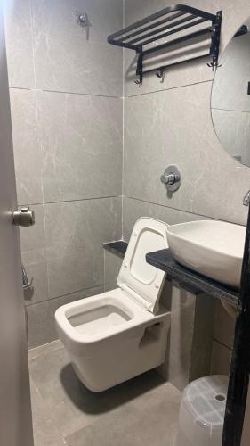 a bathroom with a toilet and a sink at Hotel M S Gold Ganadhinagar in Gandhinagar