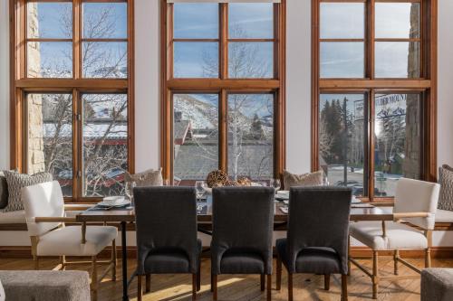 a dining room with a table and chairs and windows at Colonnade Residence 11 in Ketchum