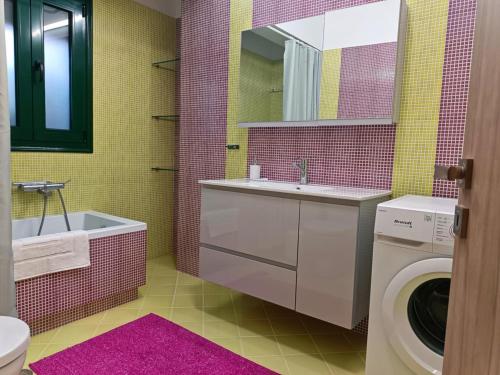a bathroom with a sink and a washing machine at Argento in Vrontádos