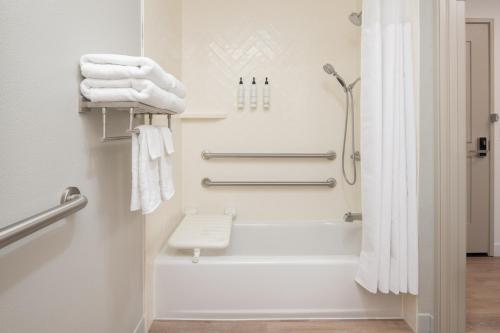 a bathroom with a shower and white towels at TownePlace Suites by Marriott Portland Airport in Portland