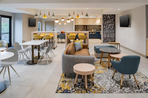 a lobby with a couch and tables and chairs at TownePlace Suites by Marriott Portland Airport in Portland