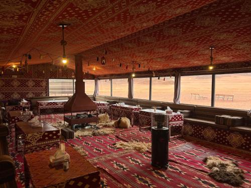 a large room with tables and chairs on a rug at wadi Rum Desert Legends in Wadi Rum