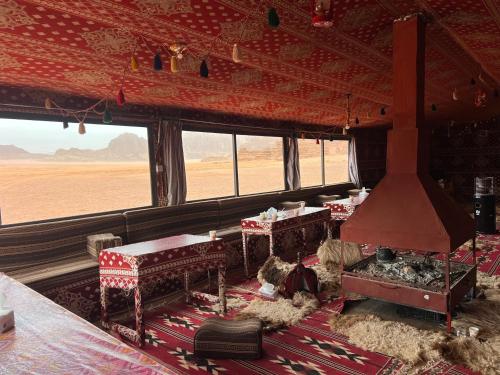 a room with tables and chairs in a room with a view of the desert at wadi Rum Desert Legends in Wadi Rum