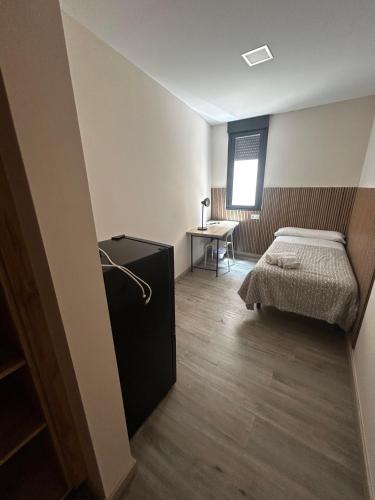a bedroom with a bed and a desk and a table at Coliving Leon in León