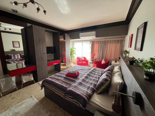 a bedroom with a large bed and a living room at Deluxe Apartment Partial Nile View in Cairo
