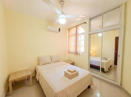 a small room with a bed and a mirror at Costambar Ocean Breeze - Beachfront Apartment with Pool in San Felipe de Puerto Plata