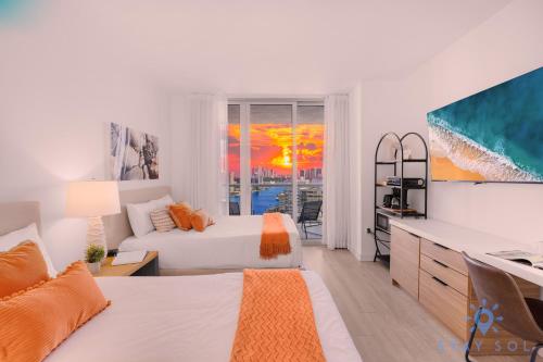 a white bedroom with two beds and a television at Beachwalk Condo in Hallandale Beach