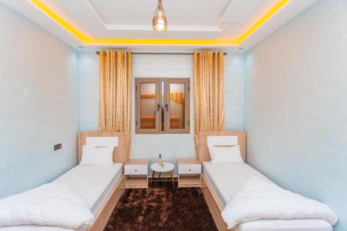 a room with two beds and a table at Appartements Meublé Désert Doré Boujdour in Cabo Bojador