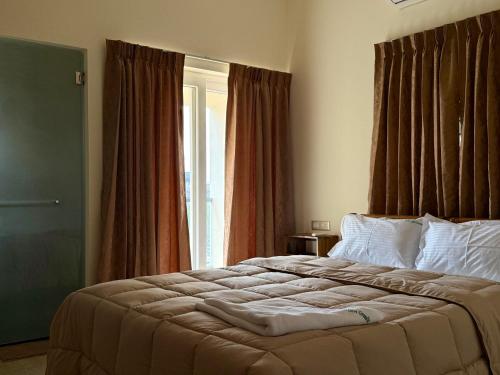 a bedroom with a large bed in front of a window at Sree Devi Grande in Chennai