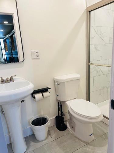 a white bathroom with a toilet and a sink at KAMA CENTRAL PARK in New York