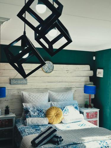 a bedroom with a bed with blue and white pillows at Tiny harties in Hartbeespoort