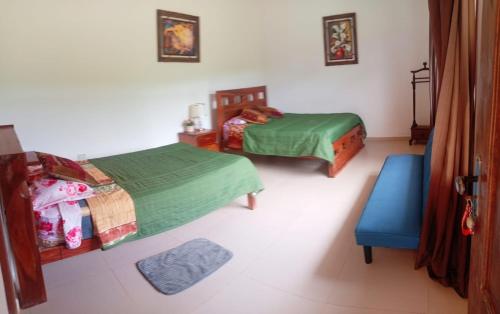 une chambre avec deux lits et une chaise bleue dans l'établissement Looking Samaipata, à Samaipata