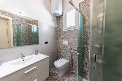a bathroom with a shower and a toilet and a sink at La Curte - B&B in Melendugno