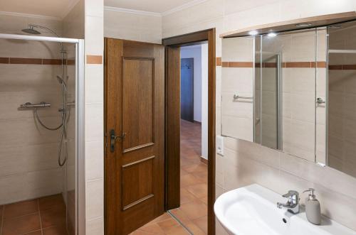 a bathroom with a sink and a wooden door at Panorama Apartments Semslach in Obervellach