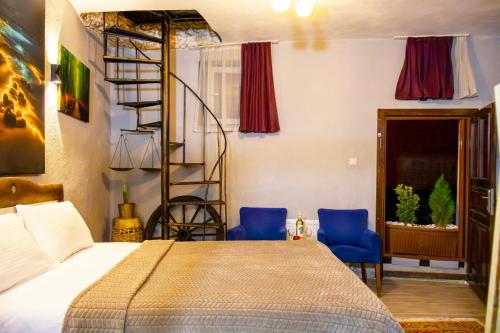 a bedroom with a bed and two blue chairs at Seten House in Ürgüp