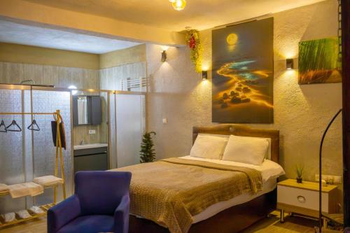 a bedroom with a bed and a blue chair at Seten House in Ürgüp