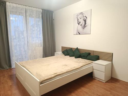 a white bedroom with a large bed and a window at Central apartment in Staré Mesto